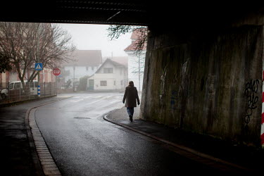 A woman walks beneath a bridge on a foggy Sunday morning in Oberursel-Stierstadt.