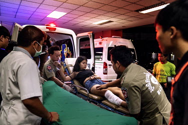 Paramedics treat woman who was riding pillion on a motorbike that was involved in a crash during Songkran festivities, when there is a spike in traffic accidents.
