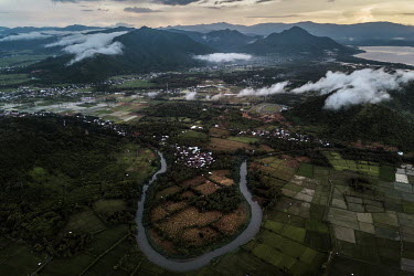 An overview of rice paddies and mountains where small-scale artisanal gold mines operate illegally on the Indotan concession.