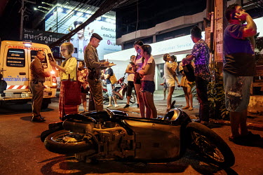 Police investigate at the scene of a crash where a drunk car driver crashed into a restaurant, another car and a motorcycle, during Songkran festivities, when there is a spike in traffic accidents.