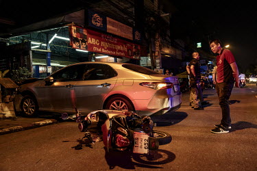 A paramedic surveys the scene of a crash where a drunk car driver crashed into a restaurant, another car and a motorcycle, during Songkran festivities, when there is a spike in traffic accidents.