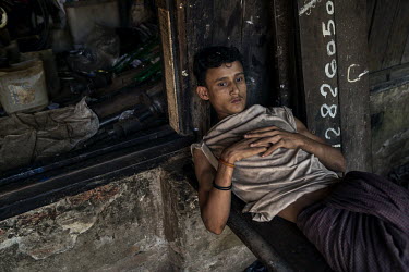 A Rohingya IDPs rests outside a metal shop near the Thae Chung IDP camp, for Rohingya displaced in the 2012 violence.
