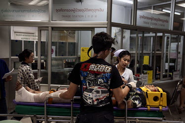 Nurses and paramedics take an injured rider, involved in a motorcycle accident, into the A&E department of a hospital, during Songkran festivities, when there is a spike in traffic accidents.