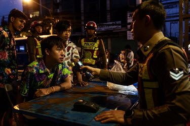 Police breathalyse and book motorbike drivers who have all tested to levels of alcohol in their breath above legal limits, at a checkpoint during Songkran festivities, when there is a spike in traffic...