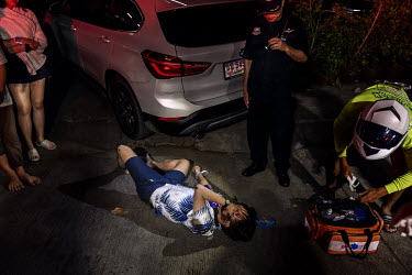 Paramedics treat a drunk motorcyclist who crashed during Songkran festivities, when there is a spike in traffic accidents.