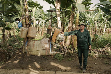 A worker at a banana plantation manouvres pesticide and fumigating devices using the plantation's cable network by which they transport the bananas. Characterised by extreme heat, humidity and extende...