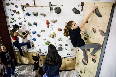 Children on a climbing wall during training at the 'Poblesec Castellers' club. The 'Castell' (castle) is a form of acrobatics involving a group creating a human castle for performances at festivals an...