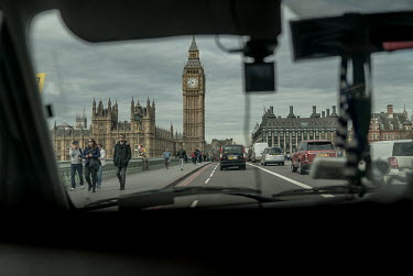 Black cab driver Paul Walsh drives his taxi over Westminster Bridge towards the Houses of Parliament and the Big Ben clock tower.