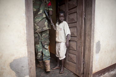 A child stands in the doorway of his home as government soldiers and Seleka fighters enter as they carry out a joint disarmament patrol, with the Multinational Force for Central Africa (FOMAC), during...