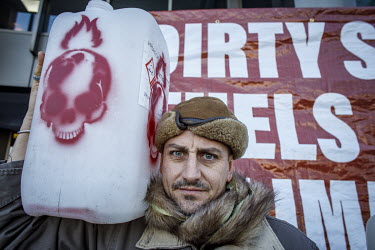 A man holds a plastic container labelled 'Hydrochloric Acid', during a protest outside the International Maritime Organisation (IMO) against the use and carriage of Heavy Fuel Oil (HFO) by ships in Ar...