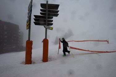 An employee moving warning signs during a storm at the ski resort of Avoriaz. Despite being less exposed than many other resorts to a lack of snow, nearly 50% of snow on this high altitude resort depe...