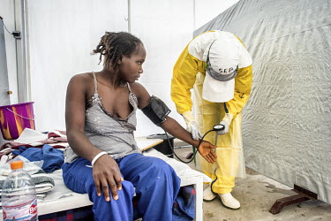 A nurse at the Ebola Treatment Centre (CTE) dressed in full personal protective equipment (PPE) takes care of patient Yama Sovigui (20) who was infected with Ebola virus by her older sister who died a...