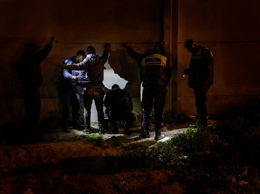 Police search suspects during a raid on a house known to be used by people using drugs. During the operation a policeman noticed that one of the young men threw something into the grass. However, afte...
