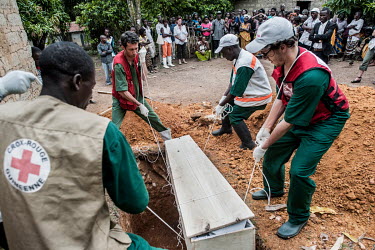 Members of the Guinean Red Cross conduct a safe burial near the home of Finda Marie Kamano (33) who died of Ebola virus just two days after she tested positive for Ebola at the Ebola Treatment Centre...