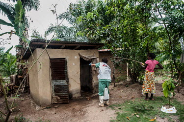 An MSF health worker sprays a toilet block with disinfectant at a house where people living there have been confirmed to be infected with Ebola virus.