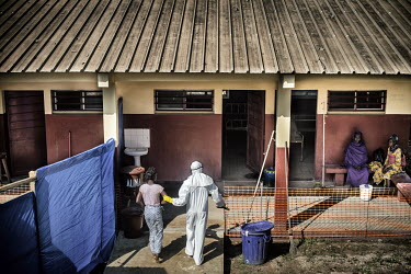 Cecile Loua (16), a student, is lead into a isolation room at the Ebola virus treatment centre (CTE) by a health worker in full personal protective equipment (PPE). She was in contact with a confirmed...