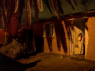 A girl stands in the doorway of her home in her pyjamas in the Bonteheuwel neighbourhood.   Bonteheuwel neighborhood is a densely populated shanty towns (or townships) mostly inhabited by poor black a...