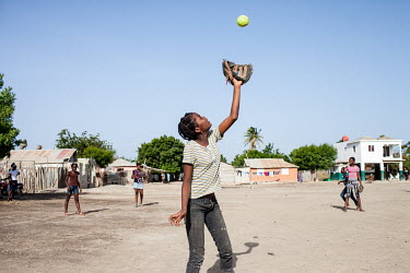 A group of girls play a baseball game in Batey No.1, near Tamayo. 'Bateys' are informal settlements that originally housed seasonal sugar plantation workers who were mostly Haitian. Due to their trans...