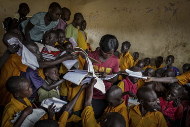 Teacher Vivian Alezuyo (27) is surrounded by eager pupils as she tries to correct every student's homework with her red pen. The school, in the Bidibidi Refugee Settlement, has far from enough resourc...