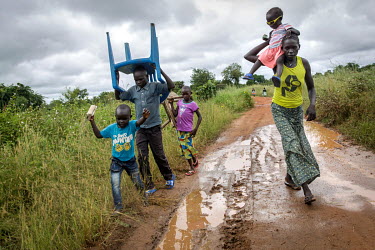 Angelina Monday (32) and her children, dressed in their Sunday clothes, make their way to church, trying their best to avoid getting dirty as they make their way along the muddy, unpaved road. Angelin...