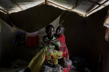 Angelina Monday (32) with two of her daughters in their home built in the Bididbidi Refugee Settlement. The family fled South Sudan in 2017 after the area where they lived was attacked by government f...