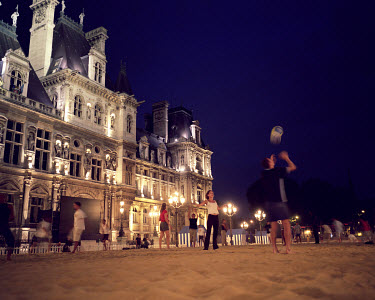 People play on an artificial beach outside the Hotel de Ville.