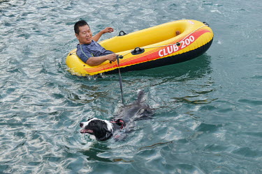 A man and his dog in a specialised 'Pet Swimming Pool', one of the protected seawater pools at Heping Island Park on Taiwan's northeast coast.