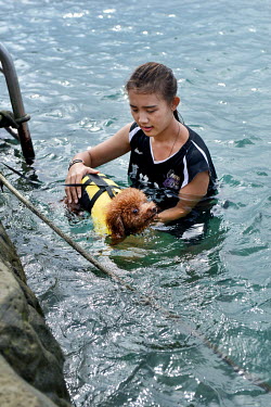 A woman with her dog in a specialised 'Pet Swimming Pool' one of the protected seawater pools at Heping Island Park on Taiwan's northeast coast.
