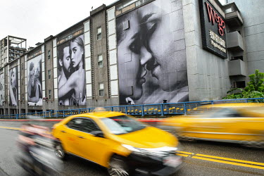 Giant photographs of couples adorn the exterior of an 'upmarket' Wego 'love hotel' where rooms can be rented on an hourly basis
