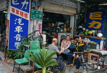 The owner and his friends pass the time of day outside an electronics workshop on Chifeng Street.