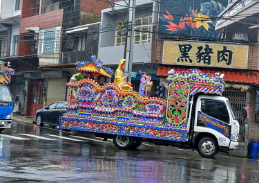 A temple God is transported on the back of a festival lorry through Guanxi Township.