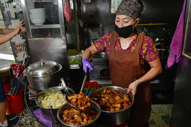 A cook dishes up stewed pork at the popular Ching Hsiang Restaurant, known for its Hakka Cuisine.