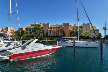 SPAIN, Andalucia: A yacht motors out of the marina at the exclusive Sotogrande community.