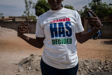 A woman wearing a t-shirt bearing the popular slogan 'Gambia has decided', a reference to the 01 December 2016 elections that eventually forced dictator Yahya Jammeh from power and into exile. She is...