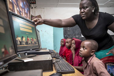 A teacher in a computer equipped classroom at the Inspirations Primary School shows her pupils how to work with new, interactive multimedia software, part of a digital learning project that, in a play...