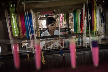 Ja Mai (23), a Kachin woman displaced by violence in northern Myanmar, works at a loom in the Palala IDP camp.