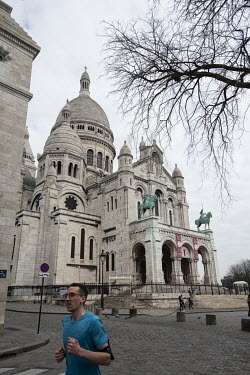 A lone runner passes Sacre Coeur and the cobblestoned streets in the Montmartre neighbourhood, normally crammed with tourists, are deserted. In response to the global spread of the novel COVID-19 viru...