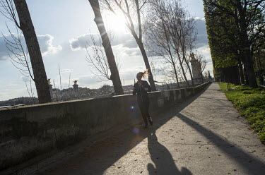 A jogger runs alongside the Seine River. In response to the global spread of the novel COVID-19 virus, the French government has imposed severe measures to stem the propagation of the coronavirus. Sch...