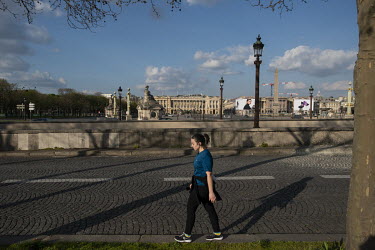 A lone walker near the Place de la Concorde. In response to the global spread of the novel COVID-19 virus, the French government has imposed severe measures to stem the propagation of the coronavirus....