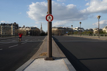 A lone bicyclist crosses the Pont de l'Alma. In response to the global spread of the novel COVID-19 virus, the French government has imposed severe measures to stem the propagation of the coronavirus....
