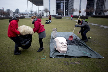 A pair of caricature model heads of German Federal Chancellor Angela Merkel, part-visible, and Federal Finance Minister and Vice-Chancellor Olaf Scholz at a demonstration, in front of the German Parli...