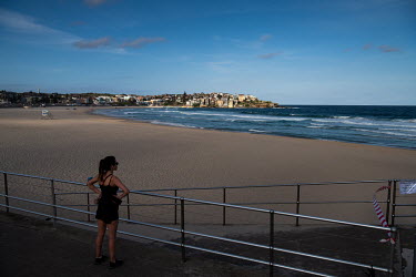 A woman looks out over a deserted Bondi Beach. Australian officials closed Sydney's iconic Bondi Beach on Saturday 21 March 2020, after thousands of people flocked there in recent days, defying social...