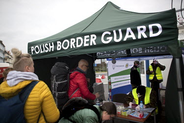 People crossing into Poland fill out forms at the Polish Border Guard post as coronavirus containment efforts are enforced on the Oder Bridge, the crossing between Germany and Poland.