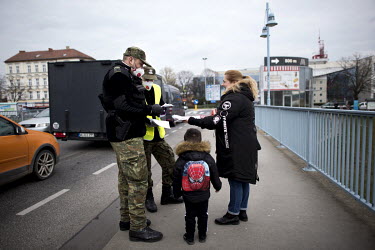 Polish border and health patrol guards, wearing face masks, check pedestrians crossing into Slubice as coronavirus containment efforts are enforced on the Oder Bridge, the crossing between Germany and...