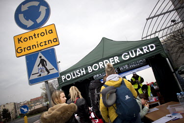 People crossing into Poland fill out forms at the Polish Border Guard post as coronavirus containment efforts are enforced on the Oder Bridge, the crossing between Germany and Poland.