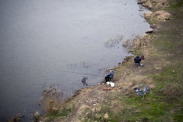 Anglers fishing on the river Oder, below the bridge at the border crossing between Germany and Poland which has become blocked with traffic as coronavirus control measures slow movement to a stand sti...