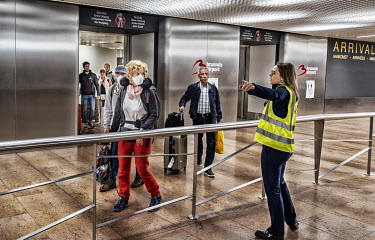 Travellers, many wearing face masks, are directed by airport staff as they enter the arrivals hall of Brussels Airport. They have been repatriated from various holiday destinations due to the coronavi...