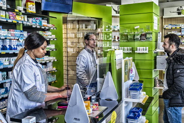 A pharmacy where the staff are now working behind a plexiglass barriers to protect themselves against possible contamination with coronavirus.