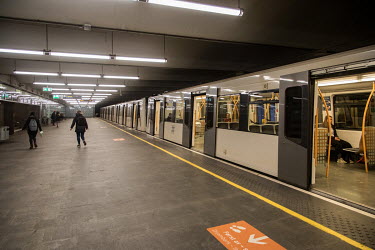 A small number of travellers alight a metro train at an unusually quiet Jernbanetorget station.  The country is in lockdown and new restrictions on public gatherings, the closure of schools, new rules...