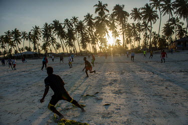 A group of men playing football on the beach at Bwejuu.